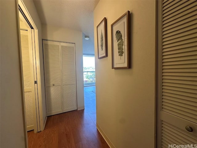 hall with dark hardwood / wood-style floors and a textured ceiling