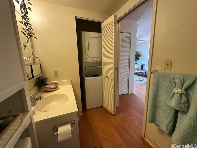 bathroom with vanity, wood-type flooring, and stacked washing maching and dryer