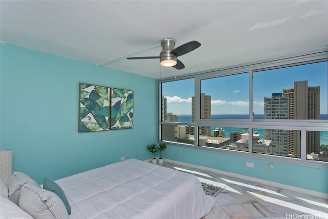 bedroom featuring a water view and ceiling fan