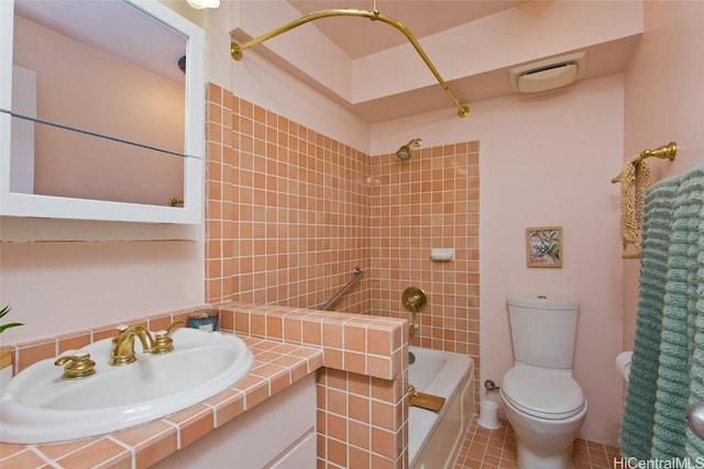 full bathroom featuring tile patterned flooring, sink, tiled shower / bath, and toilet