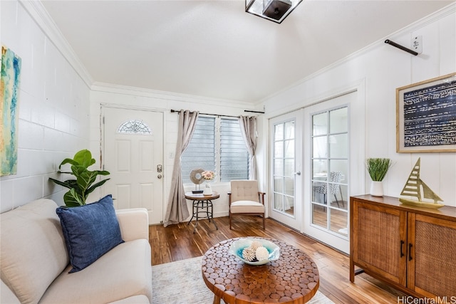 living room with french doors, ornamental molding, and wood-type flooring