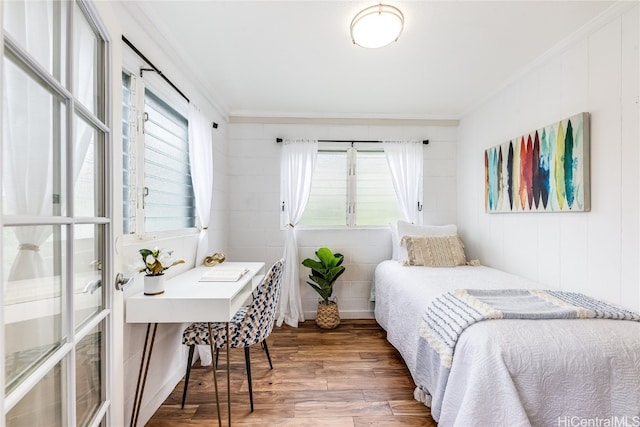 bedroom featuring multiple windows, dark wood-type flooring, and ornamental molding