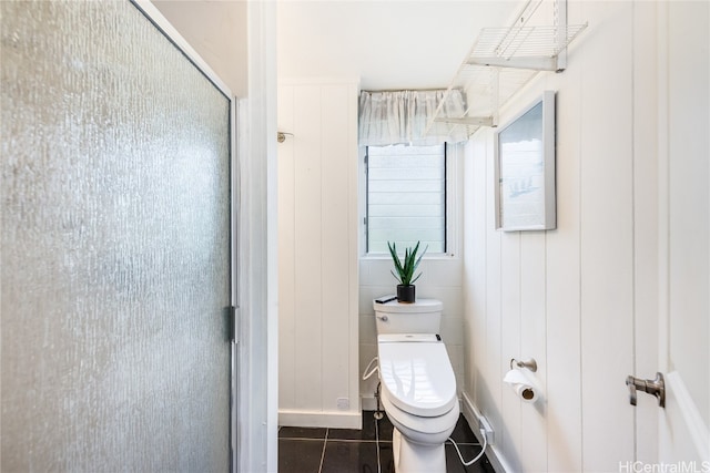 bathroom with tile patterned flooring, a shower with shower door, and toilet