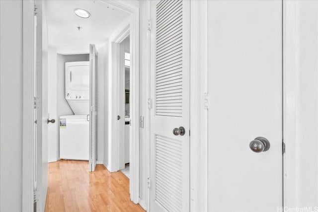 corridor featuring light hardwood / wood-style floors and stacked washer and clothes dryer