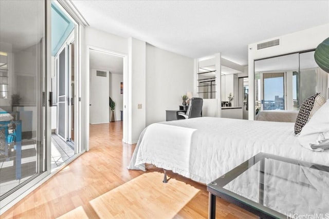 bedroom with wood-type flooring and access to outside