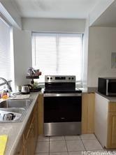 kitchen with appliances with stainless steel finishes, light countertops, a sink, and light tile patterned floors