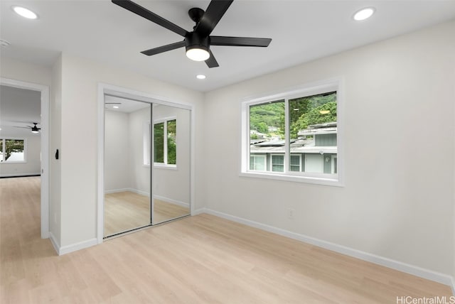 unfurnished bedroom featuring light hardwood / wood-style floors, a closet, and ceiling fan