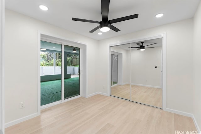 unfurnished bedroom featuring ceiling fan, access to exterior, light wood-type flooring, and a closet