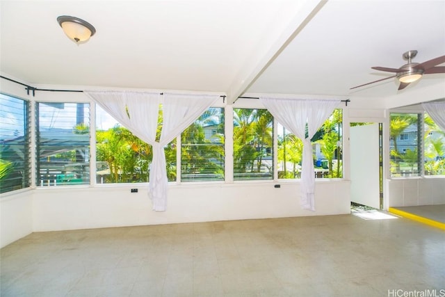 unfurnished sunroom featuring a healthy amount of sunlight and ceiling fan