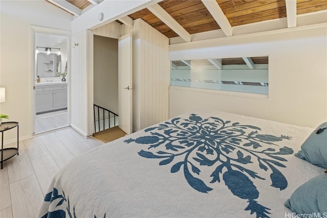 bedroom featuring hardwood / wood-style flooring, wood ceiling, beam ceiling, and ensuite bath