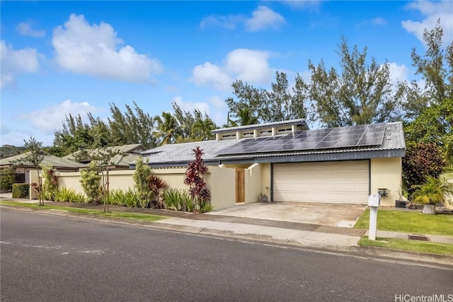 view of front of property with a garage and solar panels