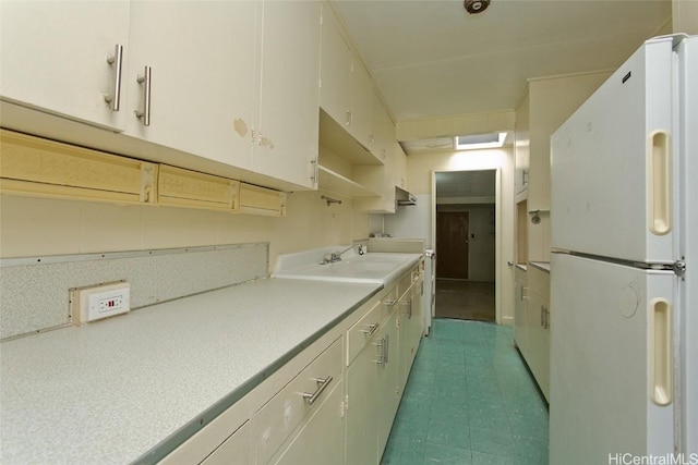 kitchen featuring white refrigerator and sink