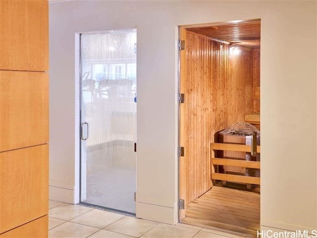 bathroom with tile patterned flooring and wood walls