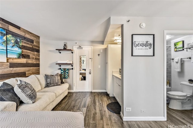 living room with hardwood / wood-style flooring and wood walls