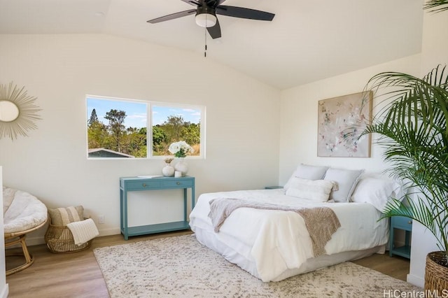 bedroom with ceiling fan, vaulted ceiling, and light hardwood / wood-style flooring