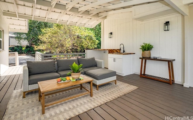 wooden terrace with an outdoor hangout area and sink