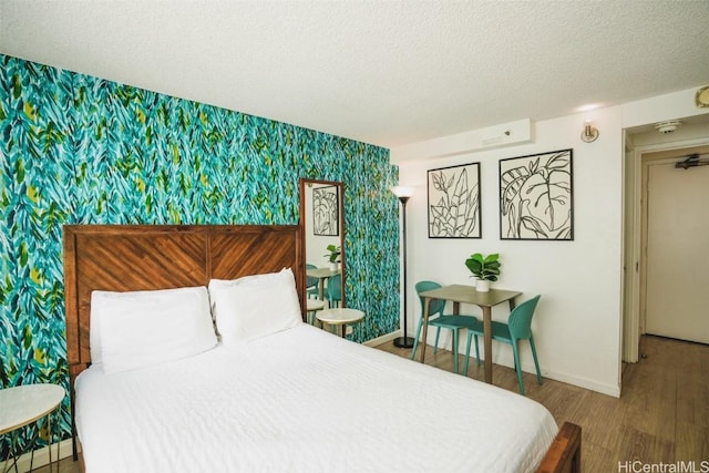 bedroom with wood-type flooring and a textured ceiling