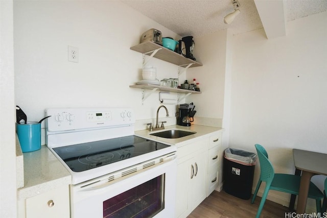 kitchen with sink, white cabinetry, electric range, wood-type flooring, and a textured ceiling