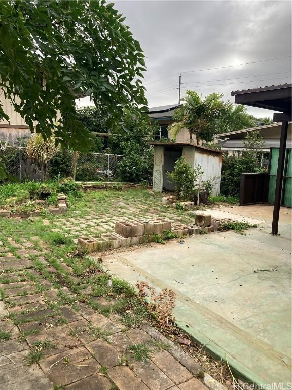 view of yard with a storage shed and a patio