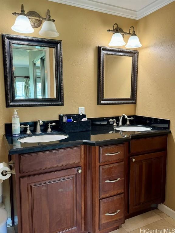 bathroom featuring tile patterned floors, ornamental molding, and vanity