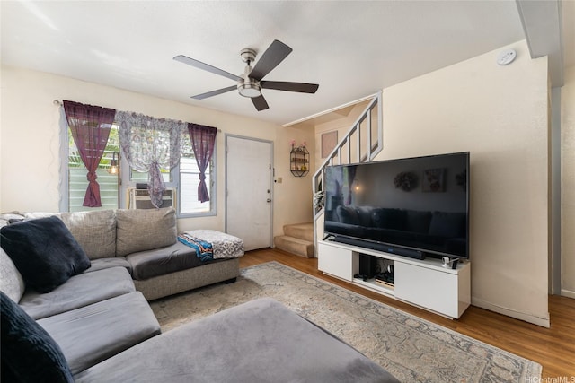 living room featuring stairs, cooling unit, wood finished floors, and ceiling fan