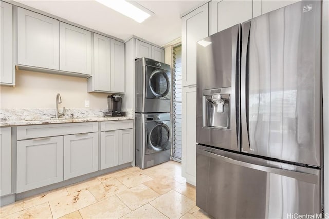 washroom featuring sink and stacked washer and clothes dryer