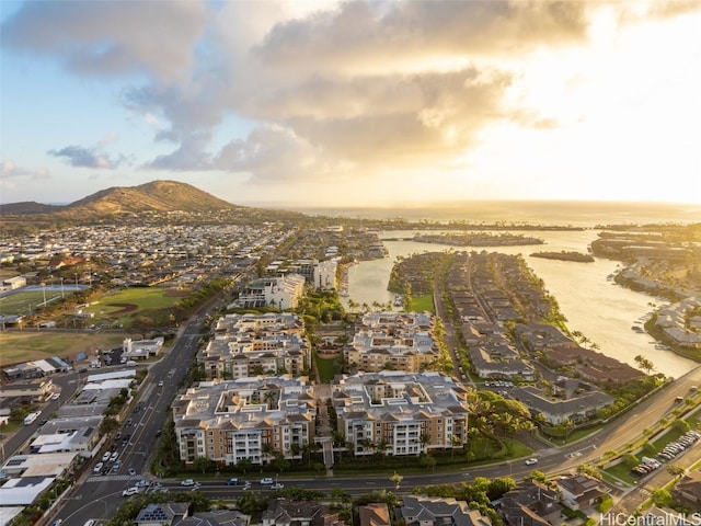 aerial view at dusk featuring a water and mountain view