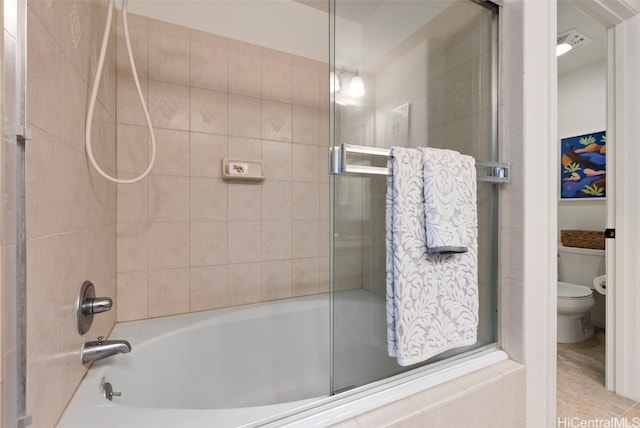 bathroom featuring bath / shower combo with glass door and toilet