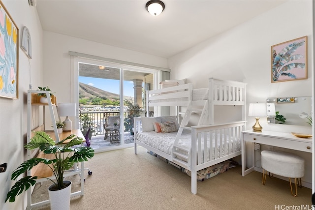 carpeted bedroom featuring a mountain view and access to exterior