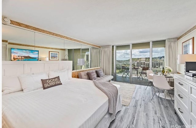 bedroom with expansive windows, access to exterior, and light hardwood / wood-style flooring