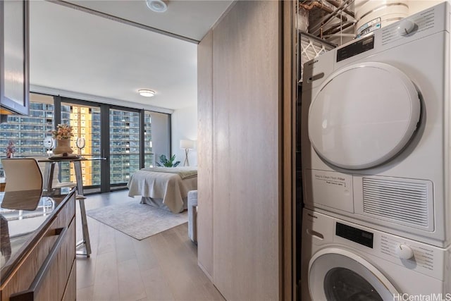 1000 Auahi St Unit 2505, Honolulu, HI 96814 - clothes washing area featuring stacked washer and dryer, light wood-style flooring, and laundry area