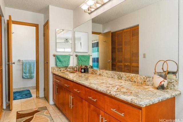 bathroom with vanity, ceiling fan, tile patterned floors, and a textured ceiling