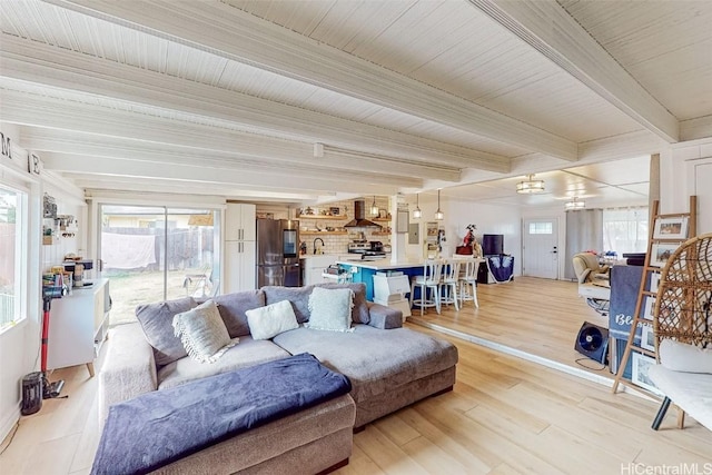 living room with beamed ceiling, sink, and light wood-type flooring