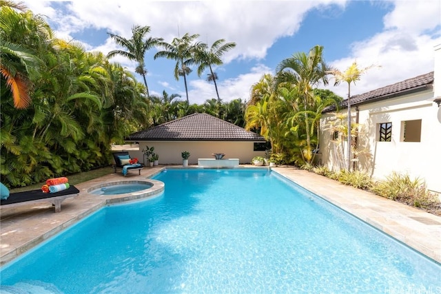 pool with an in ground hot tub and a patio area