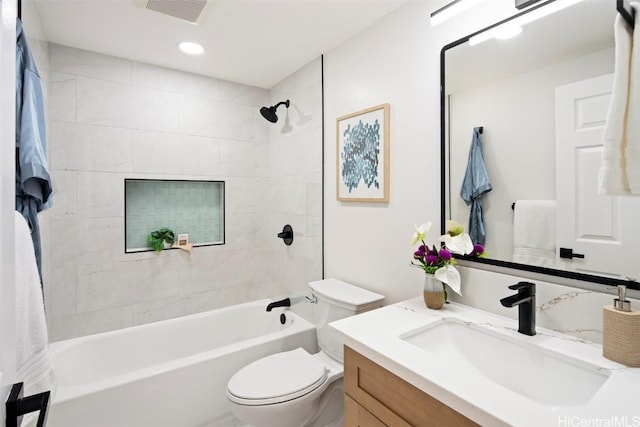 full bathroom with tiled shower / bath combo, vanity, and toilet