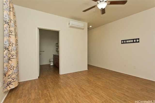 empty room featuring hardwood / wood-style flooring, ceiling fan, and an AC wall unit