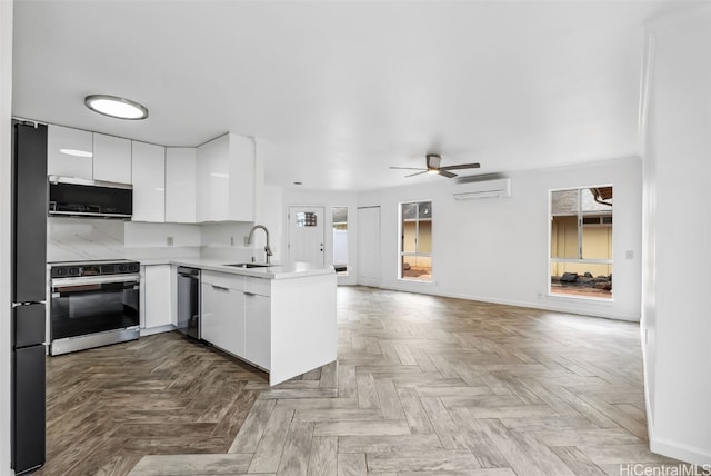 kitchen featuring range with electric cooktop, black fridge, sink, and white cabinets