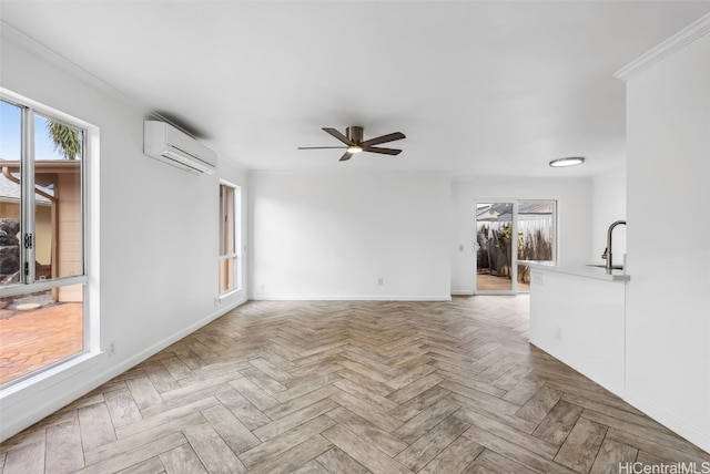 unfurnished living room with sink, plenty of natural light, a wall unit AC, ceiling fan, and light parquet flooring