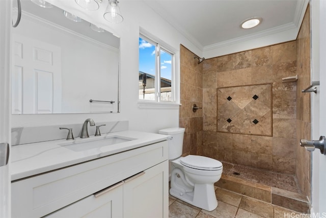 bathroom with ornamental molding, a tile shower, vanity, and toilet