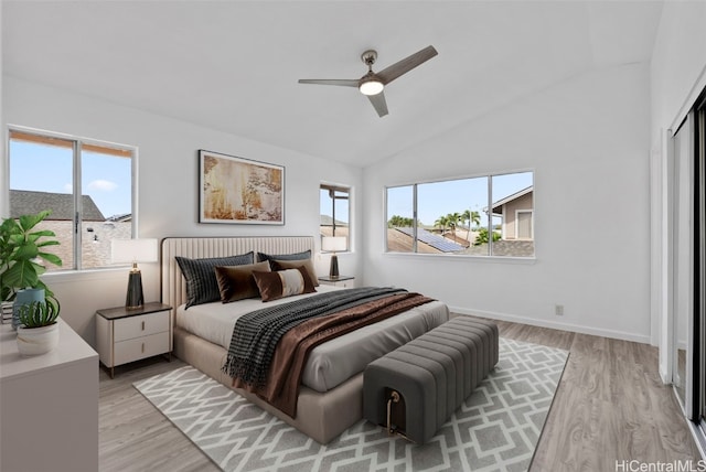 bedroom featuring multiple windows, light hardwood / wood-style flooring, and lofted ceiling