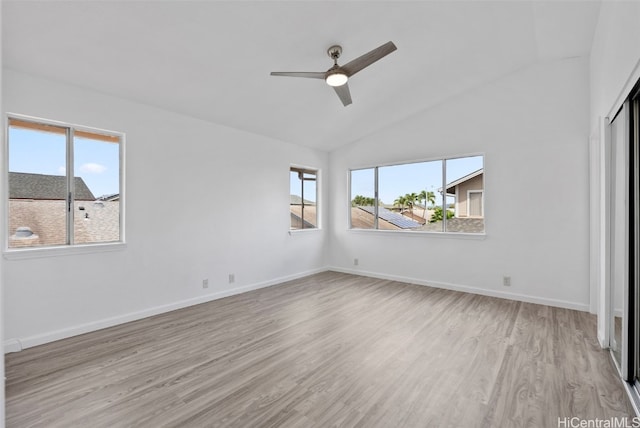 unfurnished bedroom with multiple windows, lofted ceiling, ceiling fan, and light wood-type flooring