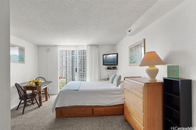 bedroom featuring light carpet and a textured ceiling