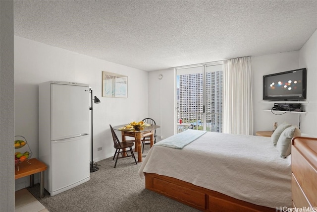 bedroom with carpet floors, white fridge, and a textured ceiling