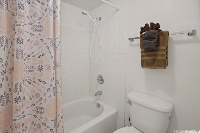 bathroom featuring shower / bath combination with curtain and toilet