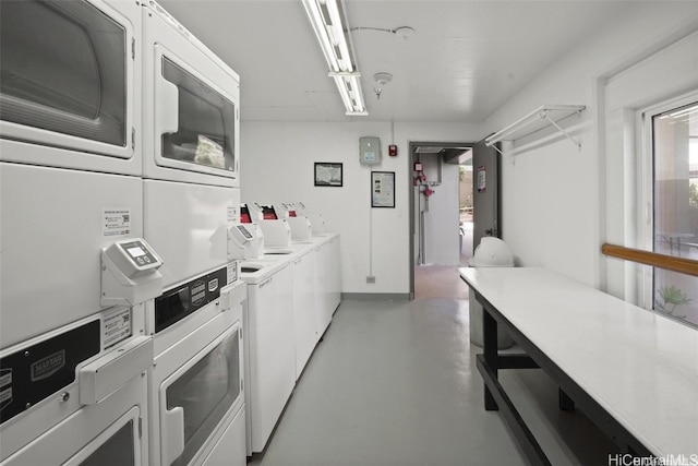 clothes washing area with stacked washing maching and dryer and washing machine and dryer