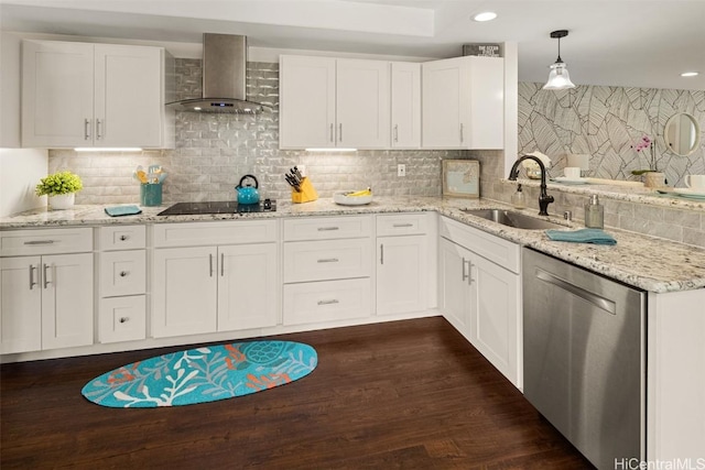 kitchen featuring wall chimney exhaust hood, decorative light fixtures, black electric cooktop, dishwasher, and white cabinets