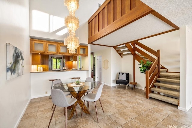 dining room featuring light tile patterned floors, a high ceiling, and a notable chandelier