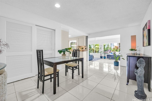 dining space featuring light tile patterned floors and a textured ceiling