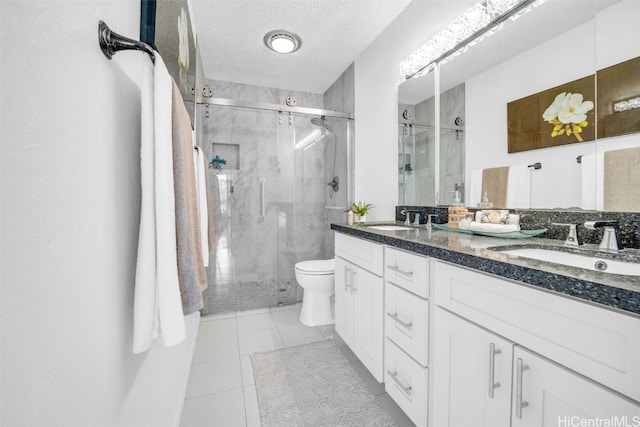 bathroom with walk in shower, tile patterned floors, a textured ceiling, and vanity