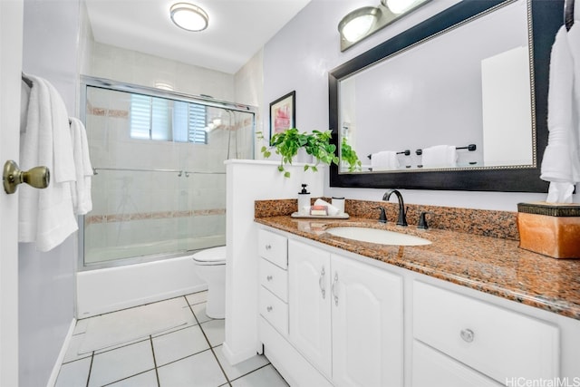 full bathroom with tile patterned flooring, vanity, shower / bath combination with glass door, and toilet